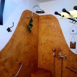a bathroom with a large wooden wall at Alpujarra Guesthouse, habitaciones en un cortijo sostenible y aislado en medio de la nada en parque natural Sierra Nevada a 1150 metros altitud in Cáñar