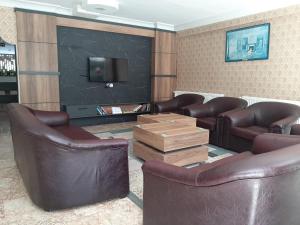 sala de estar con sillas de cuero y TV en ANTALYA Konyaaltı Gündüz Otel, en Antalya