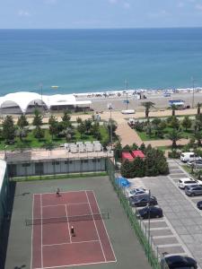 a tennis court in a parking lot next to the beach at Edo Apartment in Batumi