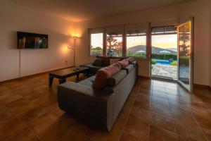 ein Wohnzimmer mit einem Sofa und einem Tisch in der Unterkunft Villa Elia with pool, Yurt and sea views in Kos-Stadt