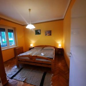 ブクにあるHorst Apartmanokのベッドルーム1室(黄色の壁のベッド1台、ランプ2つ付)