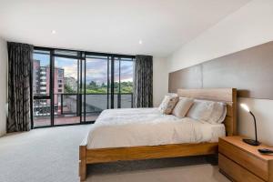 a bedroom with a large bed and a large window at Sub Penthouse Luxe suit, CBD, secure parking, in Hobart