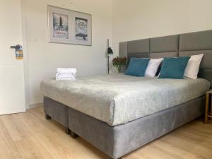 a bedroom with a large bed with blue pillows at Apartament Camilli Lackberg in Jelenia Góra