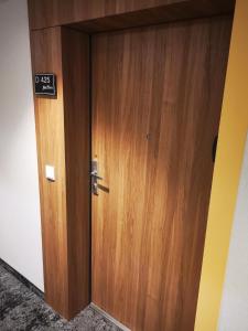 a wooden door in a room with a sign on it at Apartament 425 - Bel Mare Międzyzdroje in Międzyzdroje