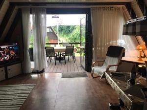 a living room with a television and a table and chairs at Domek letniskowy Julia in Ińsko