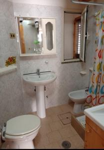 a bathroom with a sink and a toilet and a mirror at Casa Vacanze Calabria in Tropea