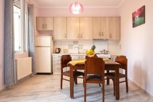 a kitchen with a table and chairs and a kitchen with a refrigerator at Villa Fotini in Sami