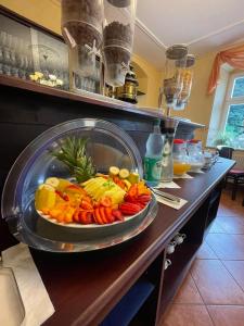 a plate of fruits and vegetables on a counter at Hotel Garni Dekorahaus in Bad Schandau