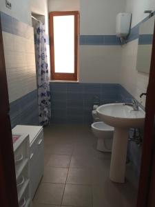 baño con lavabo y aseo y ventana en Beach Apartment 3 Only 75 M to beach, en Santa María