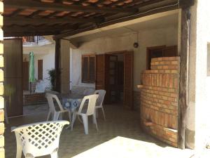 un patio con sillas blancas, una mesa y una pared de ladrillo en Beach Apartment 3 Only 75 M to beach, en Santa María