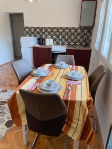 a dining room table with chairs and plates on it at Entire 1-bedroom apartment with free parking in Podgorica