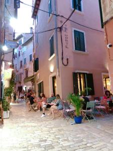 a group of people sitting in chairs on a street at Tre Porte Rovinj in Rovinj