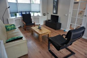 a living room with a couch and a table and a chair at Stadswoning voor jonge gezinnen en senioren in Enkhuizen