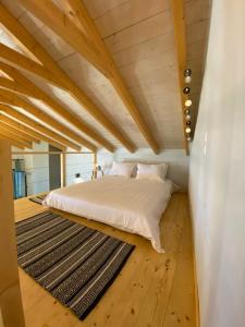a bedroom with a white bed and a black rug at Ktima Papadimitriou in Ioannina