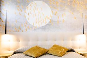 a bedroom with a bed with two gold pillows at Bellevue - Rooms & Suites in Levanto