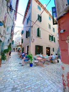 a group of people sitting at tables in an alley at Tre Porte Rovinj in Rovinj