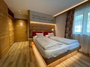 a bedroom with a large bed with a wooden headboard at B&B Cèsa Planber Mountain View in Canazei