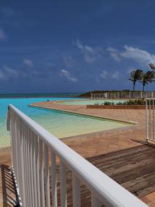 a view of the beach from the balcony of a resort at ANSE DES ROCHERS St François CORAIL 306 in Saint-François