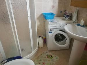a small bathroom with a washing machine and a sink at Casa Vacanza Libone in Nova Siri Marina