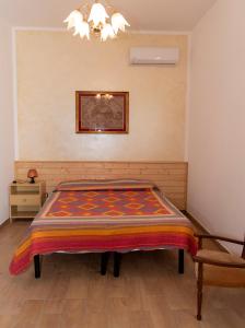 ブゼート・パリッツォーロにあるCasa Vacanze Mustazzaのベッドルーム1室(カラフルな毛布付きのベッド1台付)