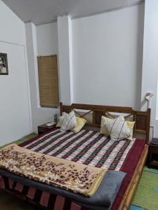 a bedroom with a bed with a blanket on it at The Mother's Riverfront in Gushaini