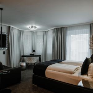 a hotel room with a large bed and a desk at The Place Boutique & Design Hotel Flachau in Flachau