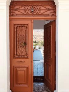 - une entrée pour un bâtiment avec une porte en bois dans l'établissement Electra, à Lindos