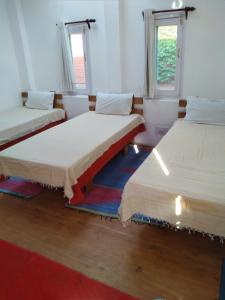 two beds in a room with two windows at The Mother's Riverfront in Gushaini