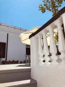 a white porch with white curtains on a house at Electra in Líndos