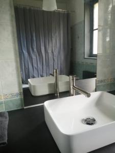 a bathroom with a white sink and a tub at Beaugency-2 sur la route des châteaux in Beaugency