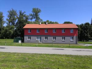 a red house with a red roof on the side of a road at Penzion Sloup in Sloup
