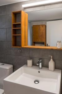 a bathroom with a white sink and a mirror at CHROMA Lodge Rafina in Rafina