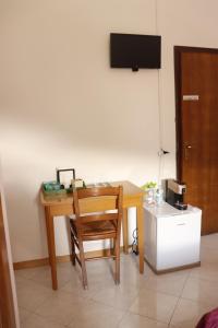 a wooden desk with a chair and a television at B&B Amico in Comano Terme