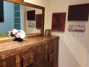 a bathroom with a mirror and a vase of flowers on a counter at Lovely apartment premium location in Ramat Gan