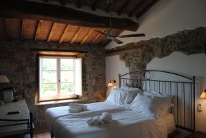 a bedroom with a bed with towels on it at VIN Hotel - Wine Resort and Agriturismo Montieri in Montieri