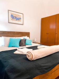 1 dormitorio con 1 cama grande con almohadas azules en Apartman Gabrijel, en Podgora