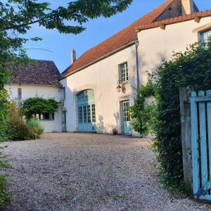 uma casa branca com portas azuis e uma cerca em Ferme équestre & Chambres d'hôtes Gateau Stables proche Guédelon em Saint-Amand-en-Puisaye