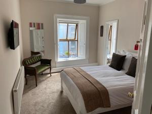 - une chambre avec un lit, une chaise et une fenêtre dans l'établissement The Old Exchange, à Clifden
