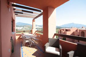 uma varanda com uma mesa e cadeiras num edifício em Hills Marbella luxury apartment Benahavis em Estepona