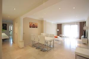 uma sala de estar com uma mesa branca e cadeiras em Hills Marbella luxury apartment Benahavis em Estepona