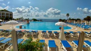 una gran piscina con sillas y sombrillas en Studio cabine vue mer, piscine panoramique, parking couvert, en Cannes