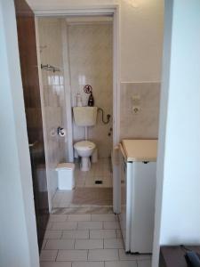a small bathroom with a toilet and a sink at Hotel Kima in Kamariotissa +64 photos