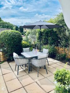 a table and chairs with an umbrella on a patio at Cotswold Chic Retreats "Cloud Nine" Central Chipping Campden-Parking-Garden in Chipping Campden +21 photos