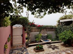 a garden with a gate and a bench and flowers at Atlantica-Home in Aourir
