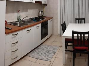 a kitchen with a sink and a stove and a table at Locazione Menini - Appartamento zona stazione in Padova