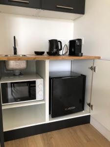 a kitchen with a counter with a microwave and a microwave at Chambre indépendante au Manoir de la Célinais côté jardin in Saint-Aubin-du-Cormier