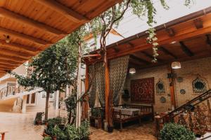 um pátio exterior com uma mesa e árvores em Hotel Dilshoda em Samarkand