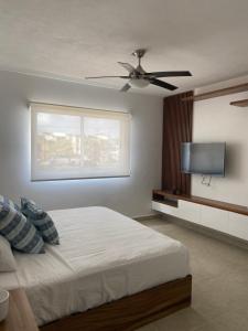 a bedroom with a bed and a flat screen tv at Liverte Cancún downtown in Cancún