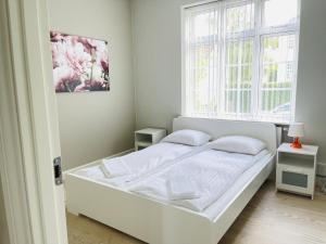 a white bed in a room with a window at aday - 2 bedroom apartment with Patio in Aalborg