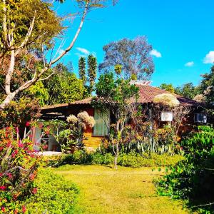 uma casa com um jardim em frente em Pousada Alfa e Ômega em Alto Paraíso de Goiás